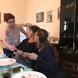 Showing Steve's, Jeff's, and Chris' family photos to Angelina and Filomena