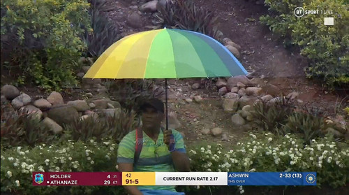 A man with rainbow umbrella sitting alone.jpg