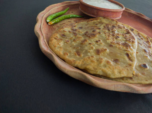 aloo paratha with curd served on plate. Traditional north indian food. Shot in black background..jpg