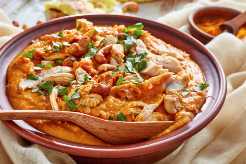 Mulligatawny soup with chicken meat and coconut milk sprinkled with fried cashew in a bowl with chap.jpg