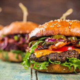 Close-up of home made tasty burgers on wooden table.