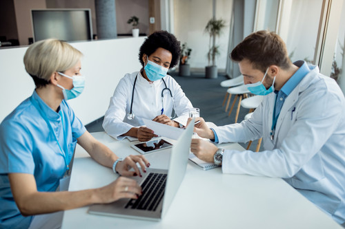 african american doctor analyzing medical reports with her colleagues clinic.jpg