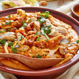 Mulligatawny soup with chicken meat and coconut milk sprinkled with fried cashew in a bowl with chap
