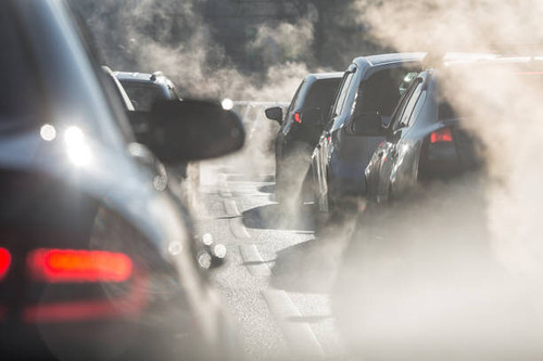 blurred silhouettes of cars surrounded by steam from the exhaust pipes.jpg