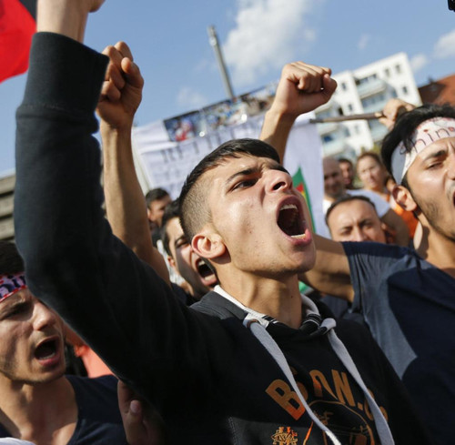 Kurds of the ethnic minority of Yazidis shout slogans against IS militants durin.jpg