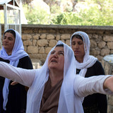 A Yazidi woman prays on the sacred grounds of Lalish.