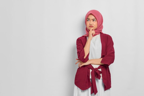 pensive beautiful asian woman casual shirt thinking about something looking away isolated white back.jpg