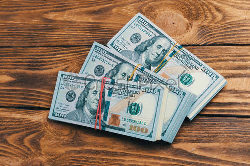 stock photo dollars in three packs on a wooden table 2646071.jpg