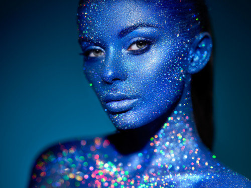 Fashion model woman in blue bright sparkles and neon lights posing in studio.  Portrait of beautiful.jpg