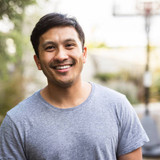Hispanic adult standing outside and smiling