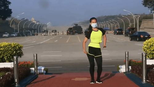 Myanmar Aerobic Instructor Performs her Workout Routine with a Coup Behind Her.png