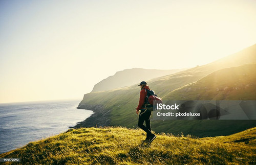 Shot of a young man hiking through the mountains.jpg