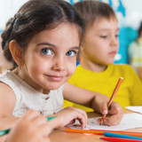 Group of cute little prescool kids drawing with colorful pencils