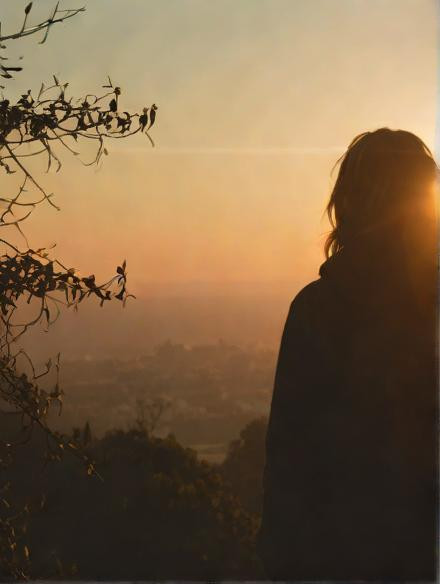 A+person+standing+on+a+hill,+watching+the+sunrise+with+a+hopeful+expression+on+their+face.jpg