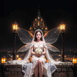 a bride sitting on a ledge with a flower bouquet . 