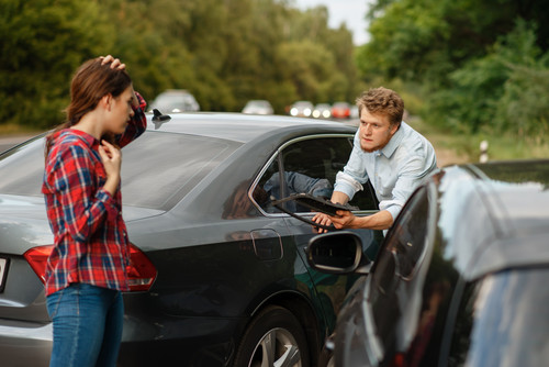 Male and female drivers on road, car accident. Automobile crash. Broken automobile or damaged vehicl