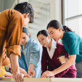 Asian businessmen and businesswomen meeting brainstorming ideas about creative web design planning a