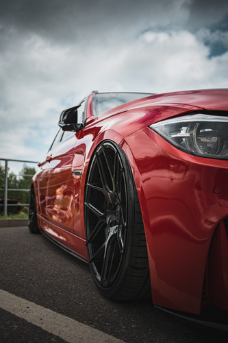 red modified bmw with black rims from low angle.jpg