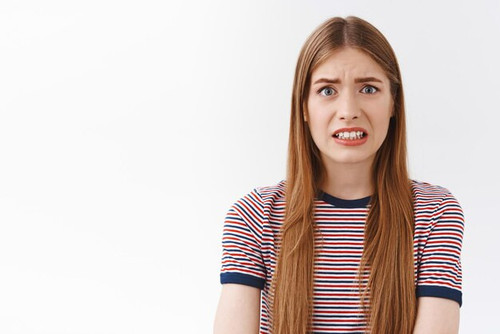 girl feeling scared consequences look embarrassed nervous cringe face clench teeth frowning bothered.jpg