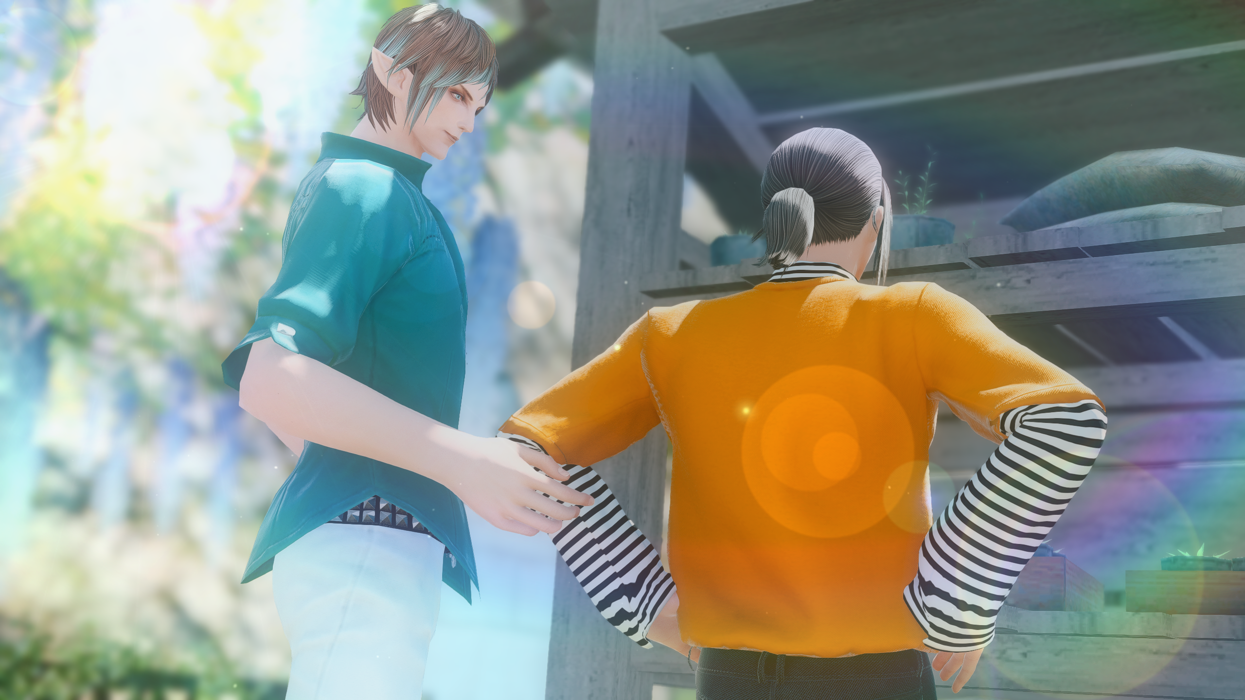 Sanson and Guydelot are standing in front of an old shed. Guydelot is touching Sanson's elbow as he looks on with soft eyes.