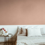 Stylish beige color bedroom with bed, linen, pillows, mirror, bedside table with red berries bouquet