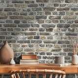 Interior design of neutral bohemian living room interior with stylish desk, armchair, dried flowers 