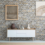 Front view of burlap artworks on a light gray wall above a wooden cupboard with decorations in real 