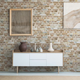 Front view of burlap artworks on a light gray wall above a wooden cupboard with decorations in real 