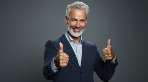 PNG shot of a handsome mature man standing against a grey background in the studio and making a thum.jpg