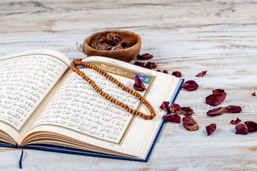 Koran - holy book of Muslims with rosary , date and dried flowers. ramadan concept.jpg