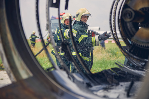 Two firemen using water from hose for fire fighting at firefight training of insurance group.jpg