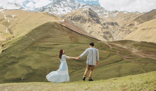 loving couple walks background high mountains with glaciers peak.jpg
