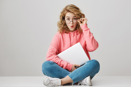 Indoor shot of interested excited young female student with curly blonde hair taking off glasses fro.jpg