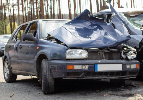 Broken car after a traffic accident in the parking lot of a repair station. Car body damage workshop.jpg
