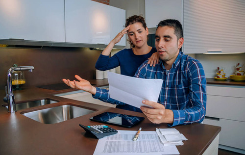 Unemployed young couple with many debts reviewing their bank accounts. Financial family problems con.jpg
