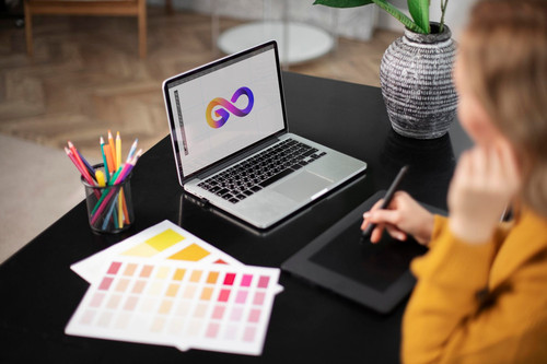 female logo designer working her tablet connected laptop scaled.jpg