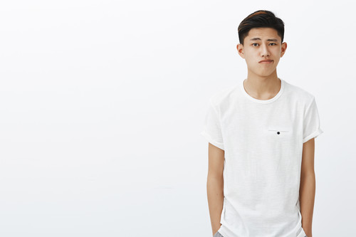 waist up shot handsome stylish korean guy white t shirt holding hands pockets smirking standing norm.jpg