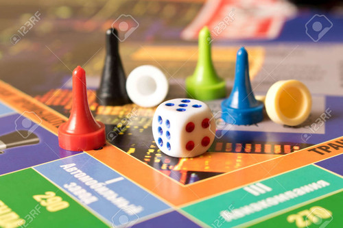 104232040 multi colored game chips with dice on the playing board board game.jpg