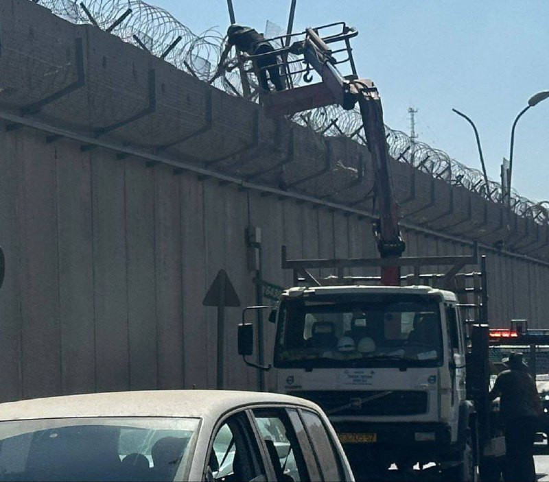 قوات الاحتلال تعزز جدار الفصل العنصري بمدّ أسلاك شائكة إضافية أعلاه، في بلدة الرام بالقدس المحتلة....