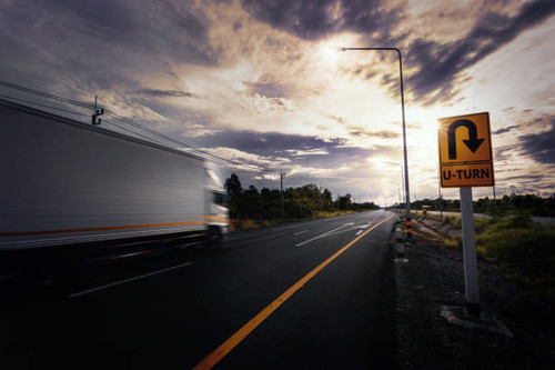 blurry container truck drive through u turn sign.jpg