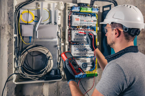 Man, an electrical technician working in a switchboard with fuses. Installation and connection of el.jpg