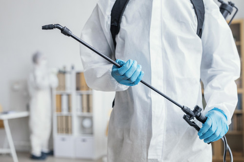 person disinfecting dangerous area while wearing protective suit.jpg