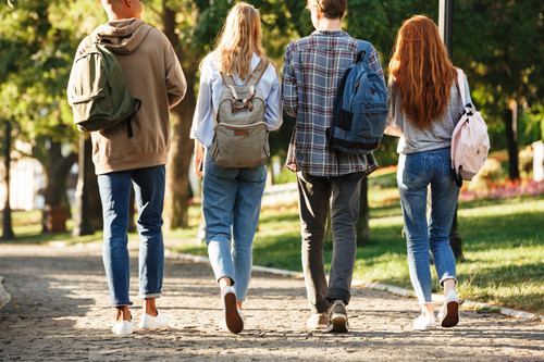 Back view group of students with backpacks walking at the campus outdoors.jpg