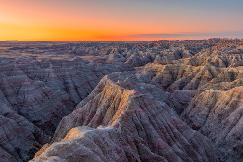 a large canyon with a sunset with Badlands National Park in the background.jpg