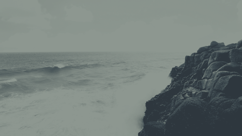 a person standing on a rocky cliff by the ocean.png
