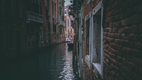 a canal between buildings with boats.jpg