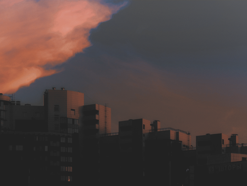 a city skyline with a sunset in the background.png