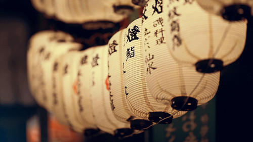 a group of white lanterns with black writing on them.jpg