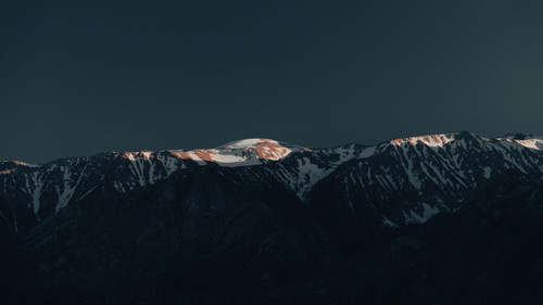 a snowy mountain top with dark sky.jpg