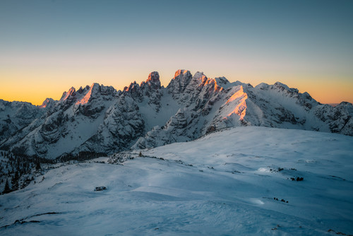 a snowy mountain range with sun shining on it.jpg